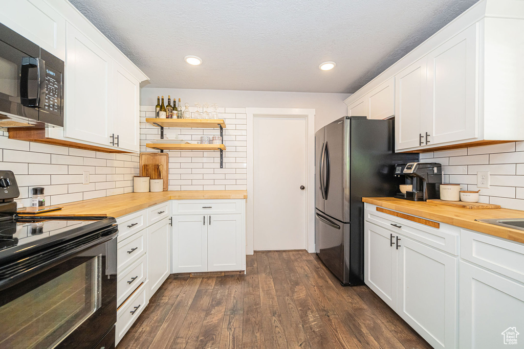 Kitchen with wooden counters, black appliances, open shelves, dark wood finished floors, and white cabinetry