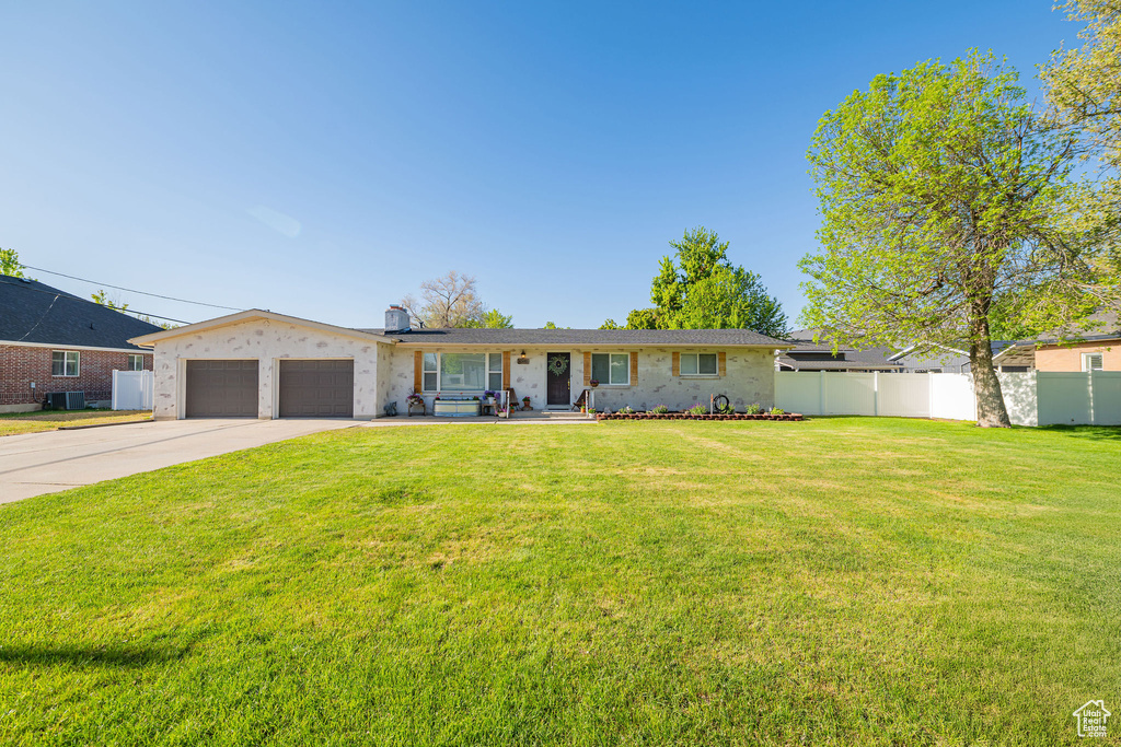 Ranch-style house with an attached garage, driveway, central AC, a chimney, and brick siding
