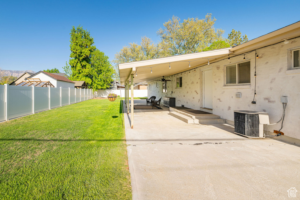 View of yard featuring a patio, ceiling fan, and cooling unit