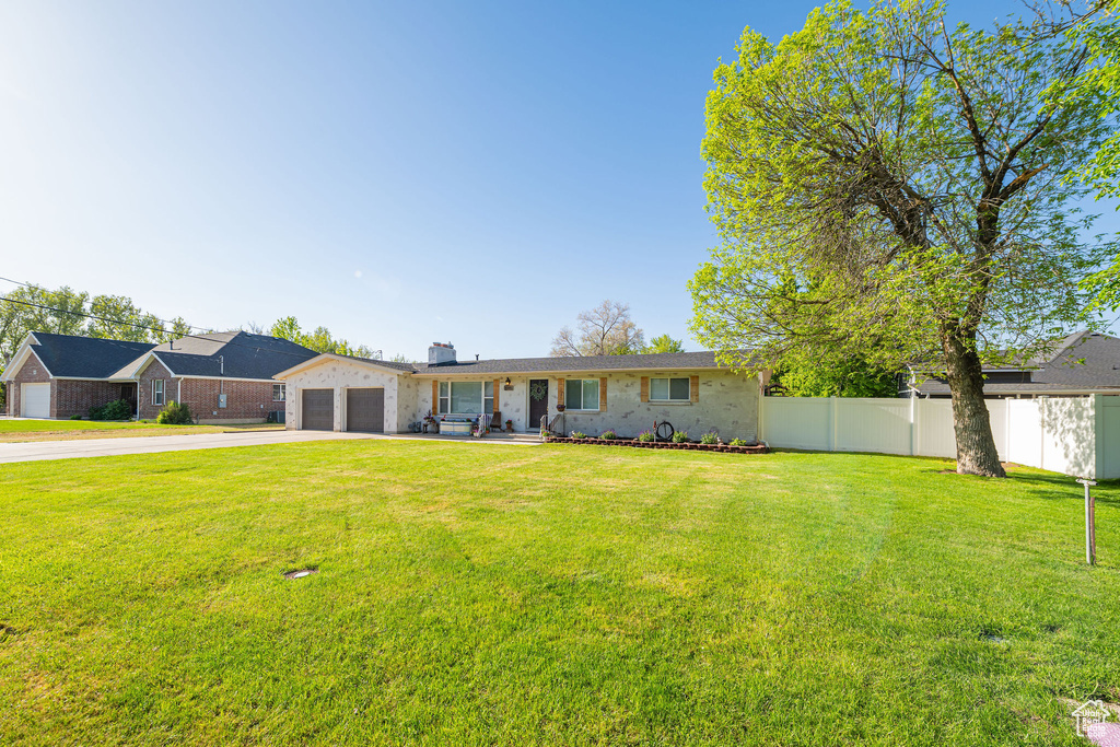 View of front of property with driveway, an attached garage, a chimney, and brick siding