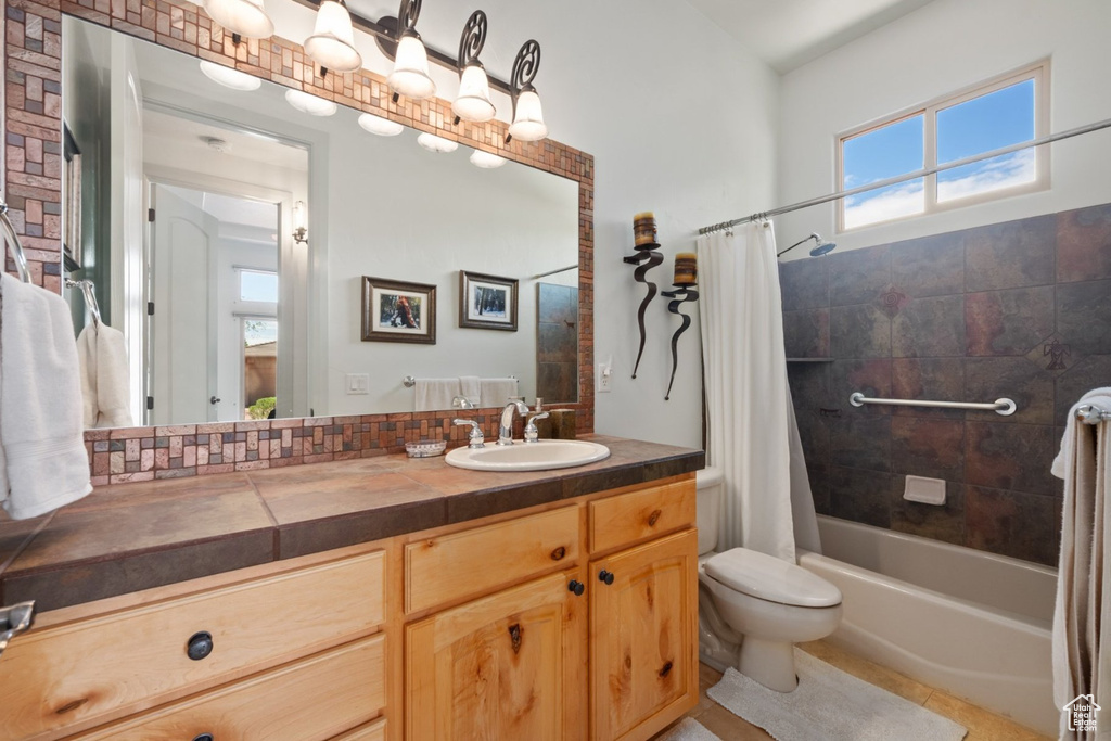 Full bath featuring toilet, vanity, shower / bathtub combination with curtain, and tile patterned flooring