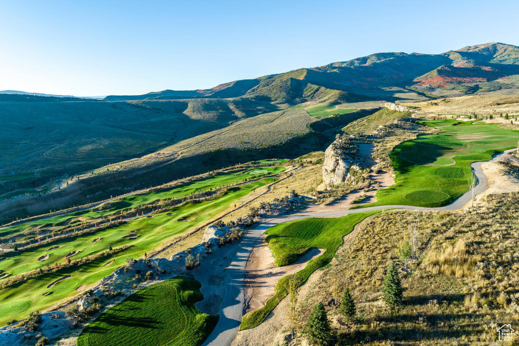 Aerial view of property and surrounding area with a mountain backdrop and a golf club