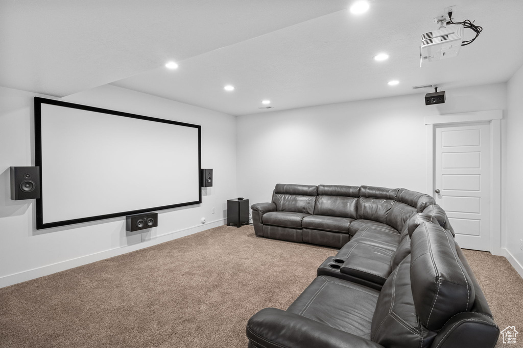 Carpeted cinema room with recessed lighting and baseboards