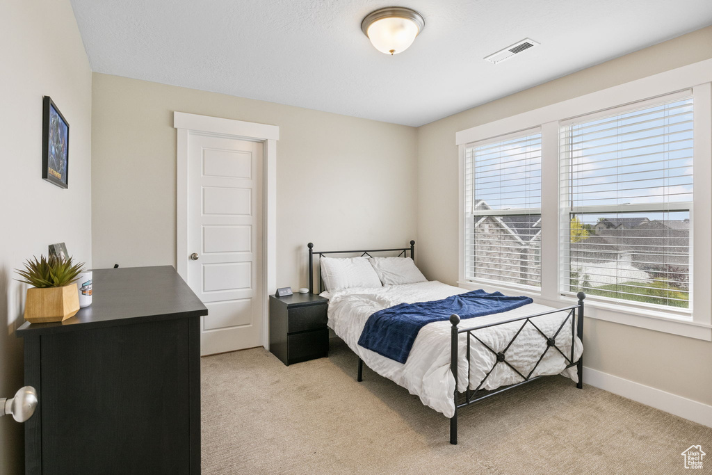 Bedroom featuring light carpet and baseboards