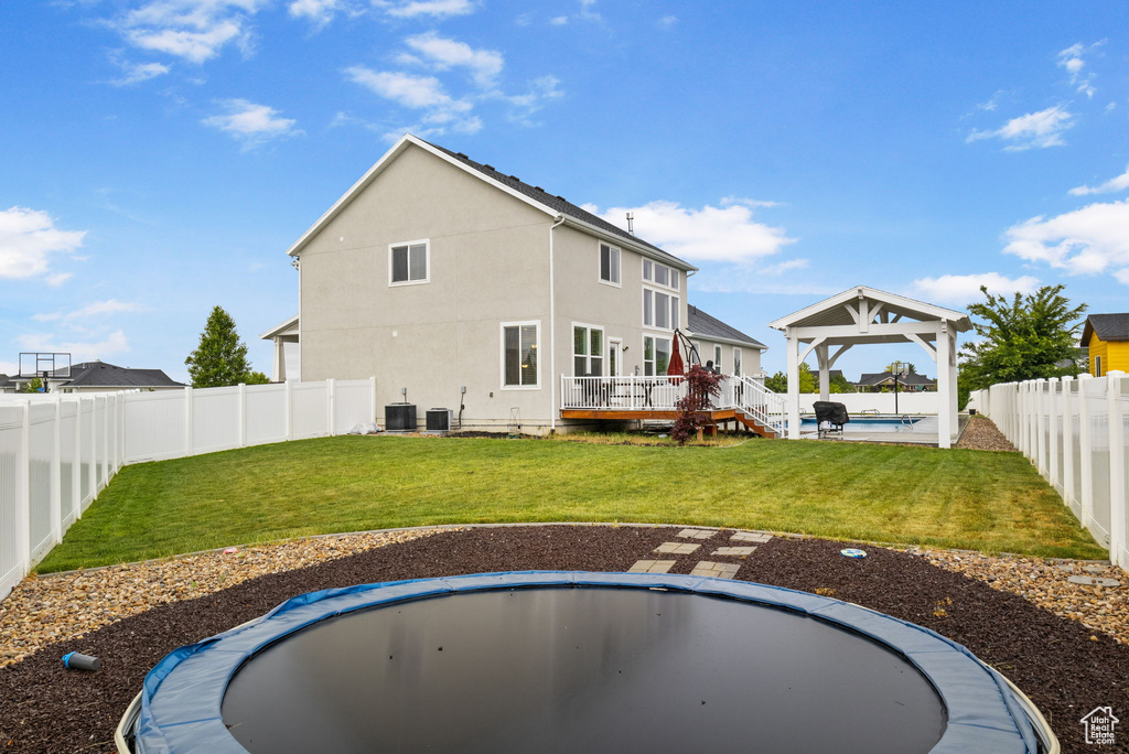 Rear view of house with a gazebo, central air condition unit, stucco siding, and a deck