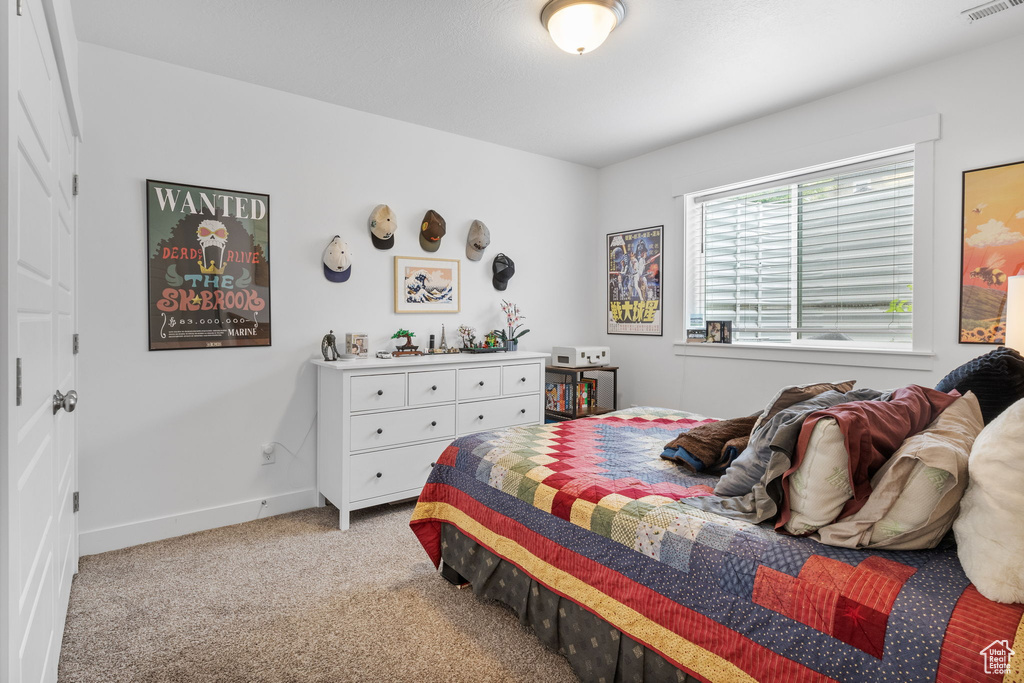 Bedroom featuring light colored carpet and baseboards