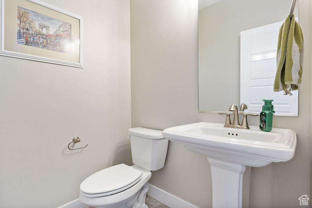 Half bathroom with baseboards and toilet