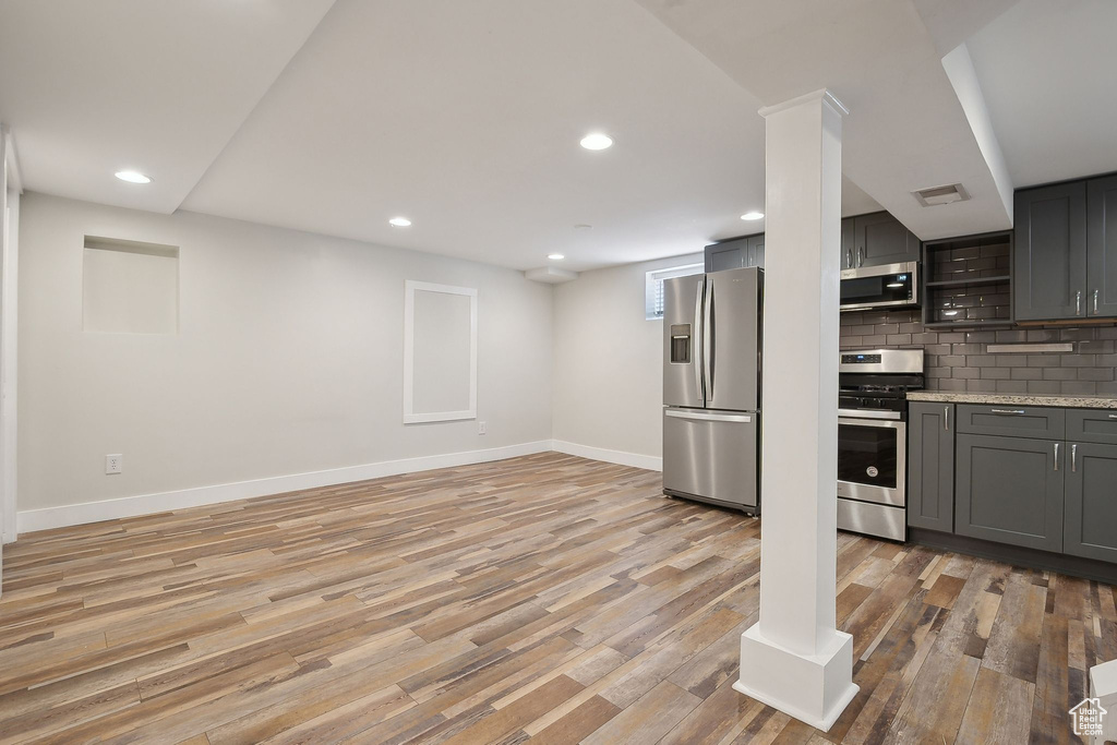 Kitchen with stainless steel appliances, gray cabinetry, light wood-style floors, baseboards, and recessed lighting