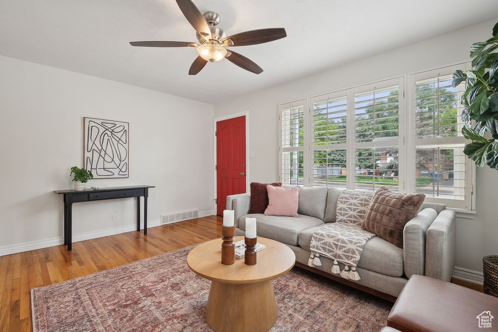 Living area featuring a ceiling fan, wood finished floors, and baseboards