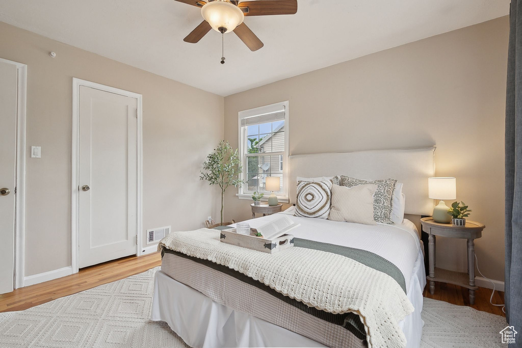 Bedroom featuring light wood-type flooring, baseboards, and a ceiling fan
