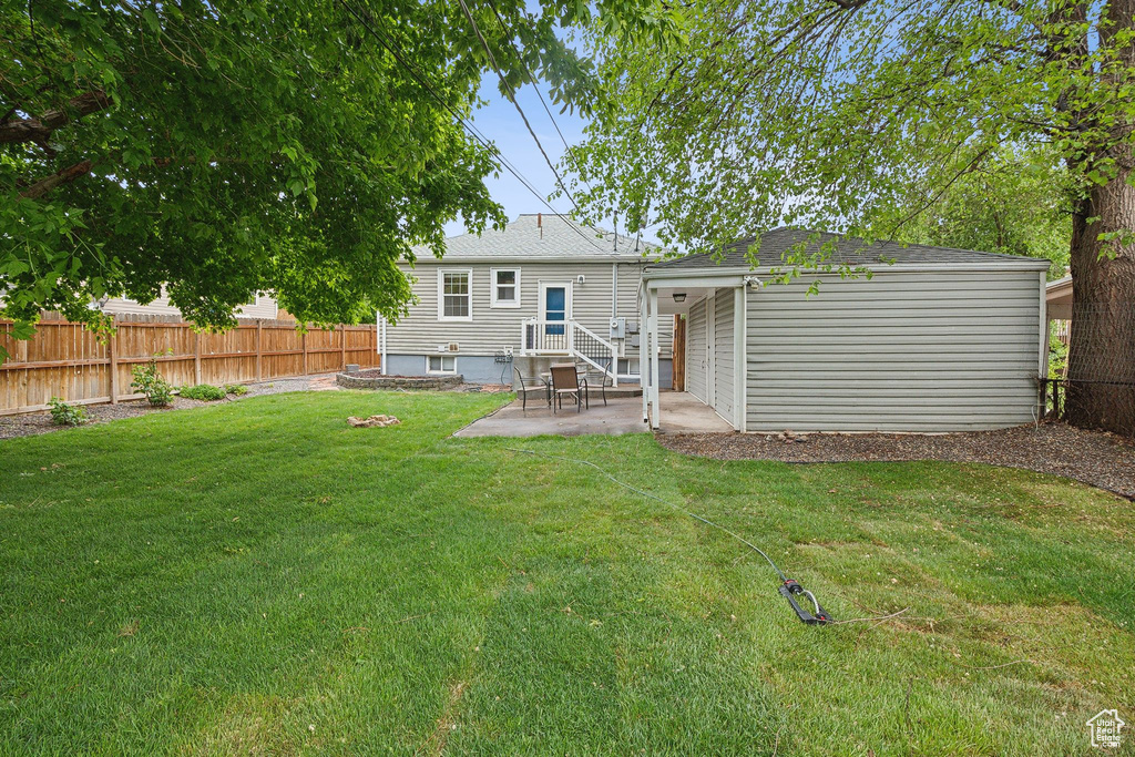 Back of property with a patio area and roof with shingles