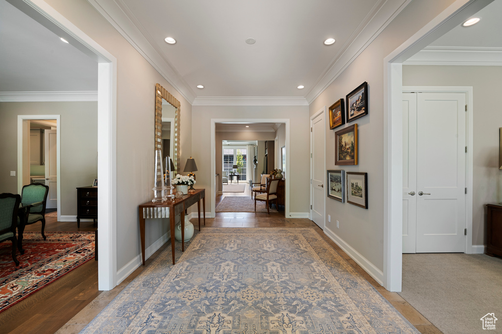 Hallway featuring crown molding, recessed lighting, baseboards, and wood finished floors