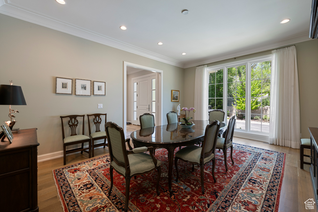 Dining space with ornamental molding, recessed lighting, light wood-type flooring, and baseboards