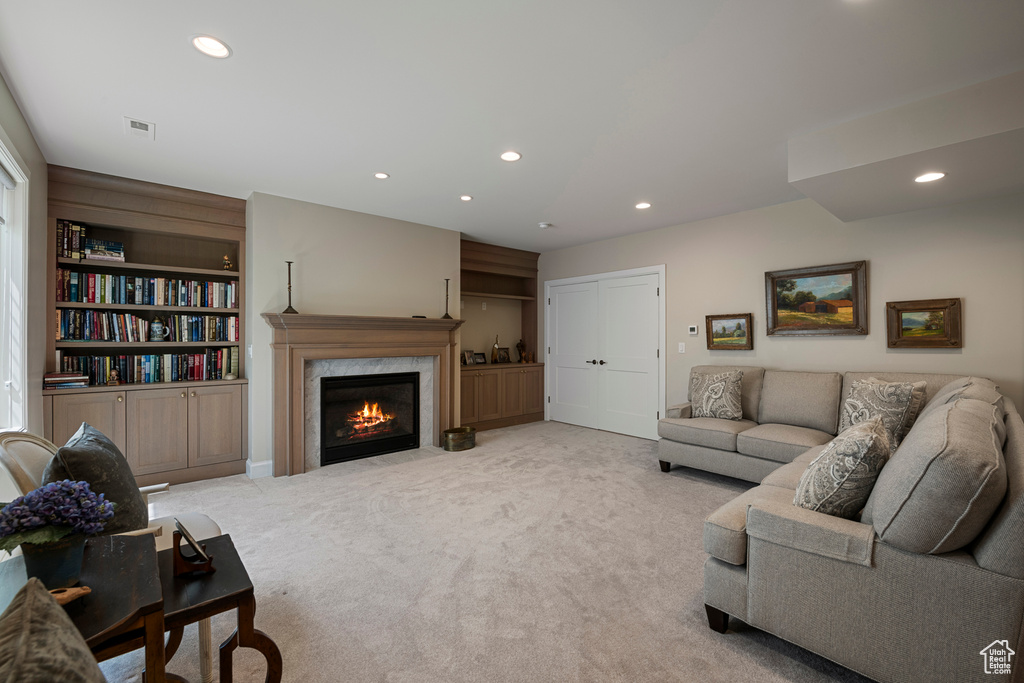 Living area with recessed lighting, carpet, and a fireplace