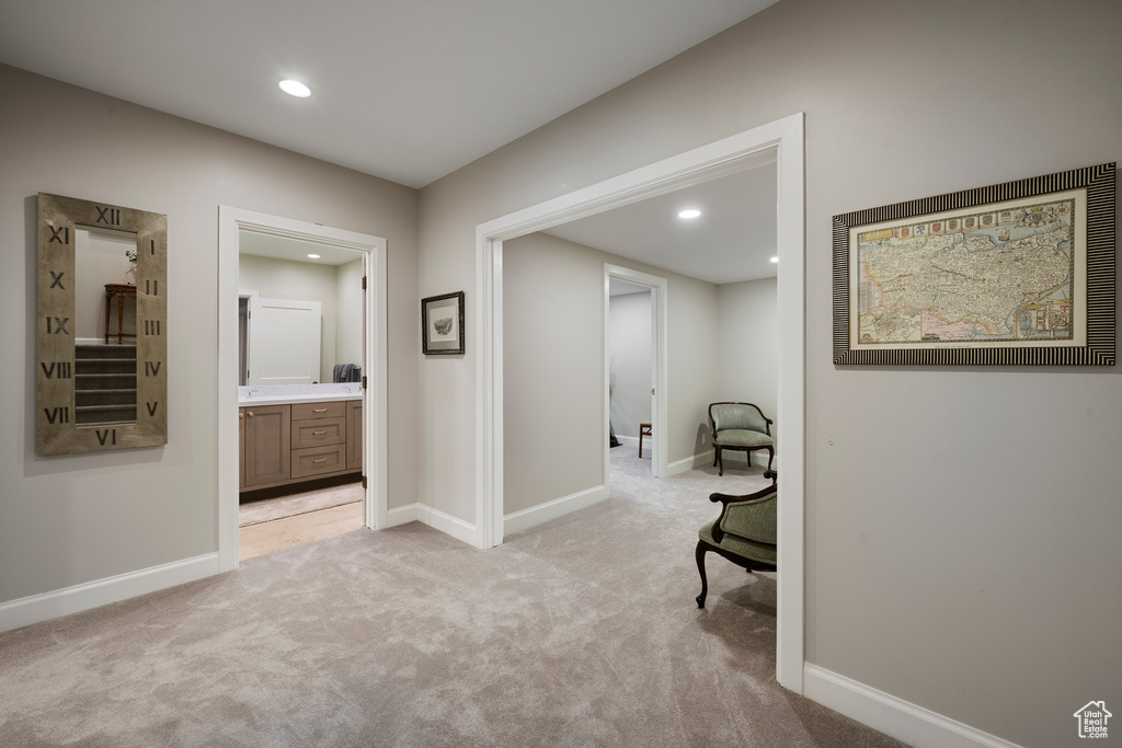 Corridor featuring light colored carpet, baseboards, and recessed lighting