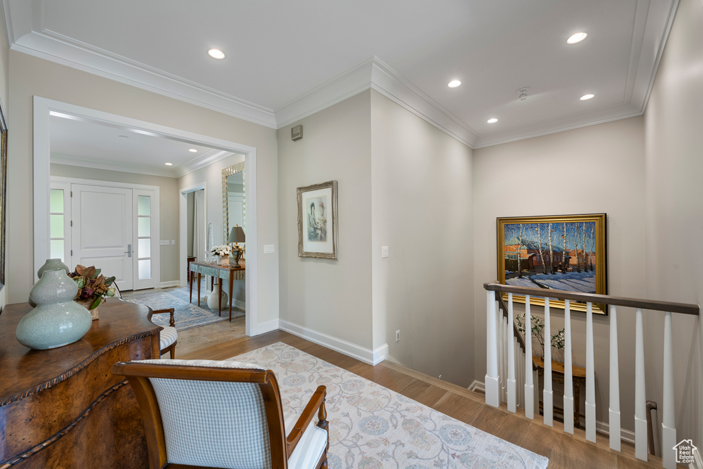 Hallway featuring wood finished floors, baseboards, recessed lighting, an upstairs landing, and ornamental molding