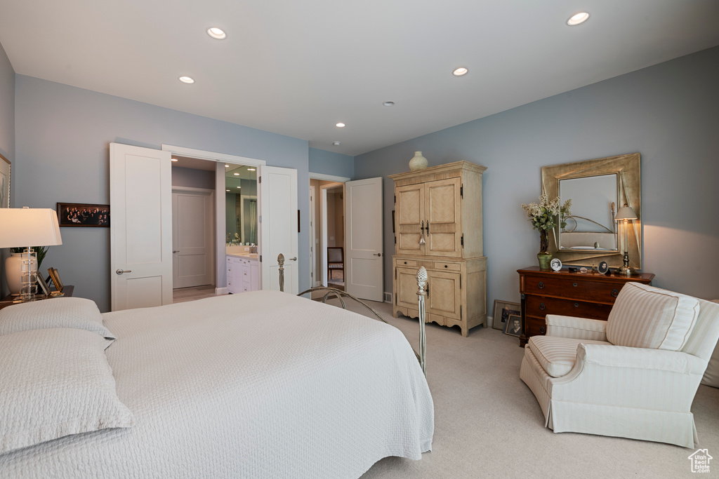 Bedroom with recessed lighting, light carpet, and connected bathroom