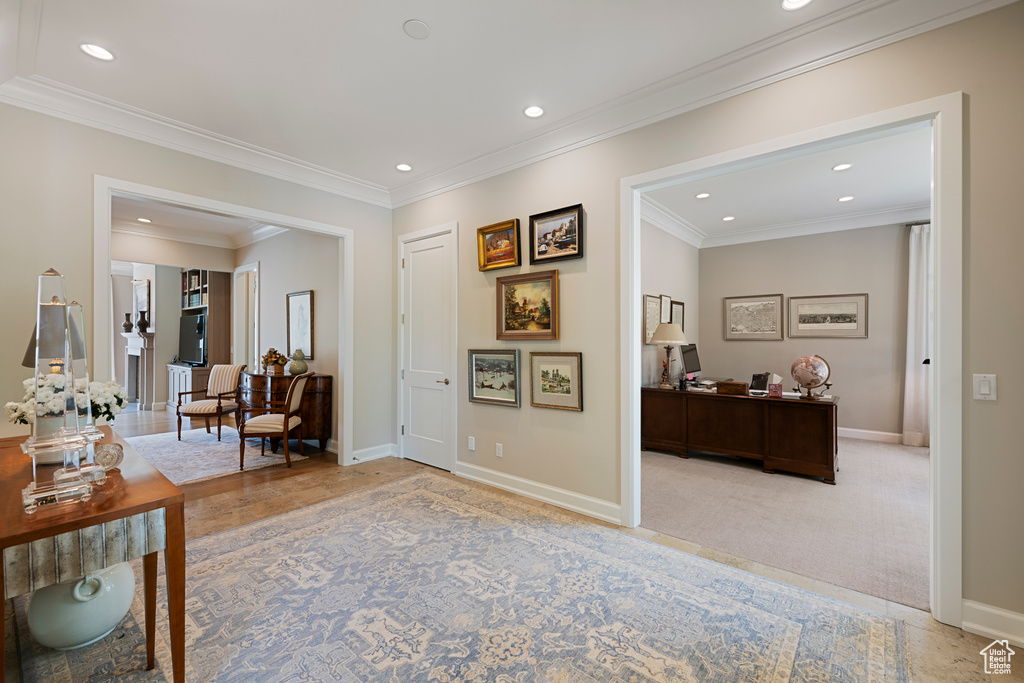 Hallway featuring baseboards, recessed lighting, ornamental molding, and light colored carpet