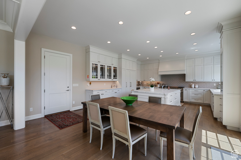 Dining space with dark wood finished floors, recessed lighting, and baseboards