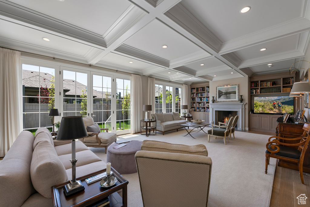 Living area featuring coffered ceiling, beamed ceiling, a lit fireplace, ornamental molding, and recessed lighting