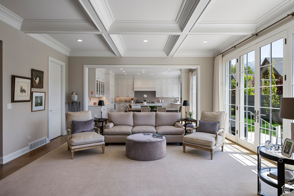 Living area with beam ceiling, coffered ceiling, ornamental molding, recessed lighting, and baseboards