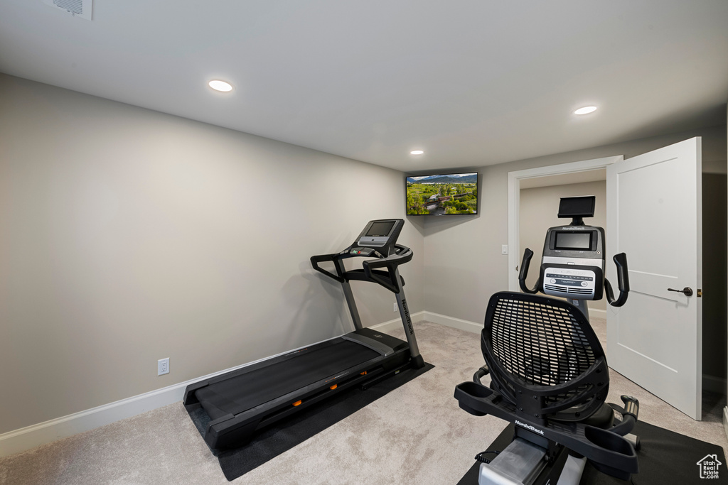 Exercise room featuring light colored carpet, baseboards, and recessed lighting
