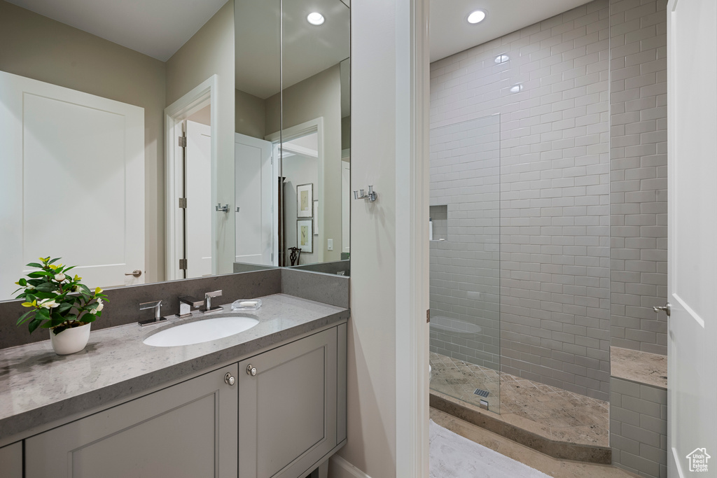 Bathroom with walk in shower, vanity, recessed lighting, and baseboards