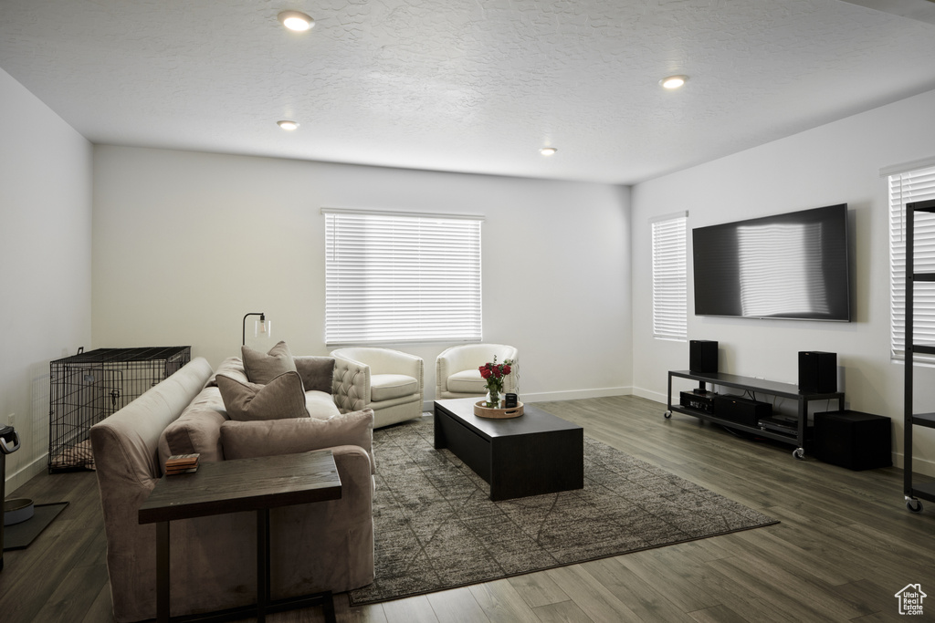 Living room with wood finished floors, baseboards, and recessed lighting