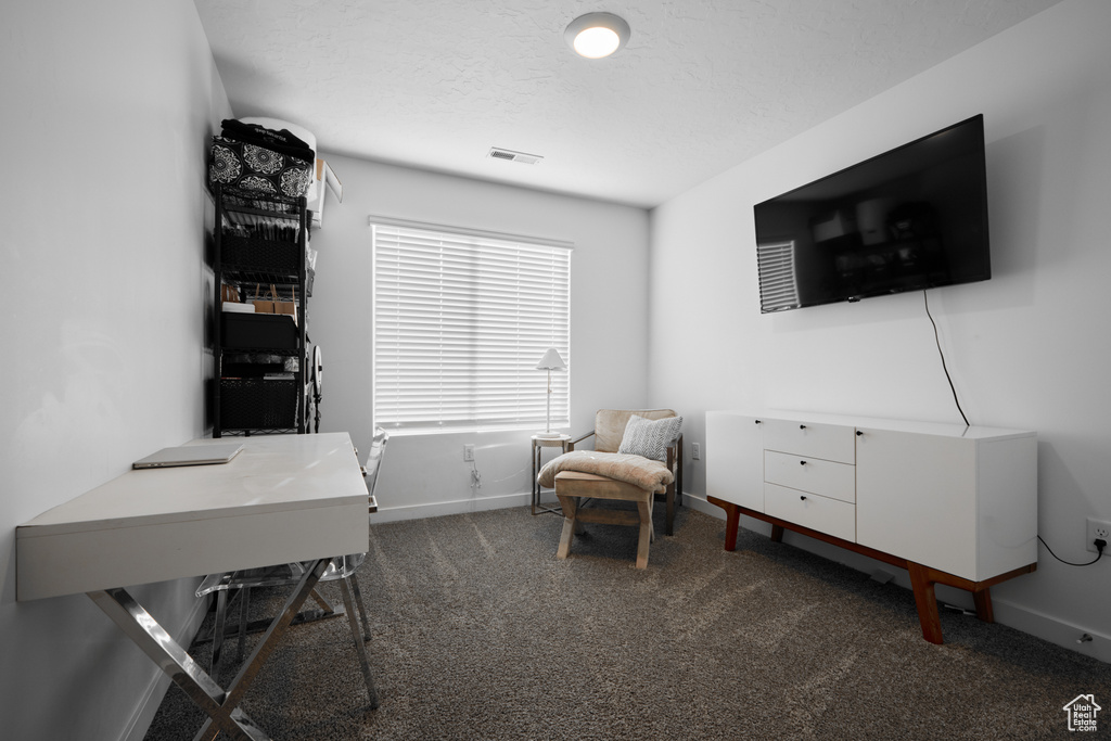 Office space with dark carpet and baseboards