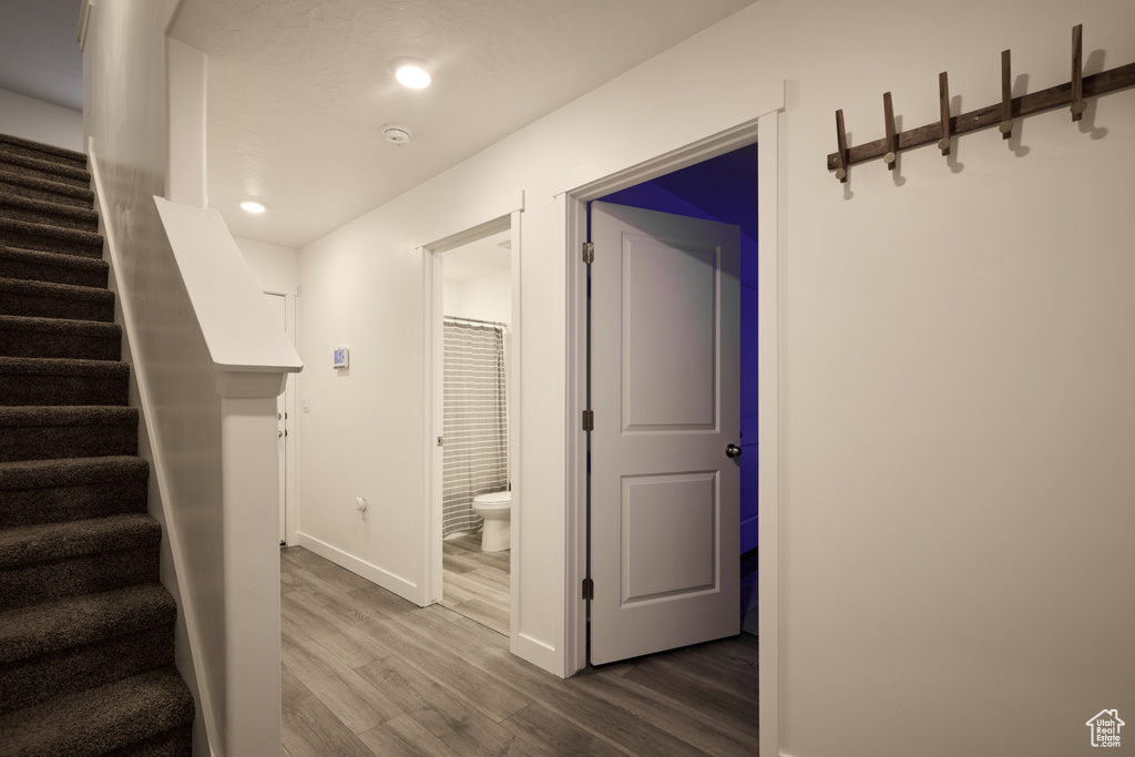 Stairs with wood finished floors, baseboards, and recessed lighting