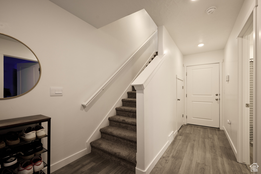 Stairway with wood finished floors, baseboards, and recessed lighting