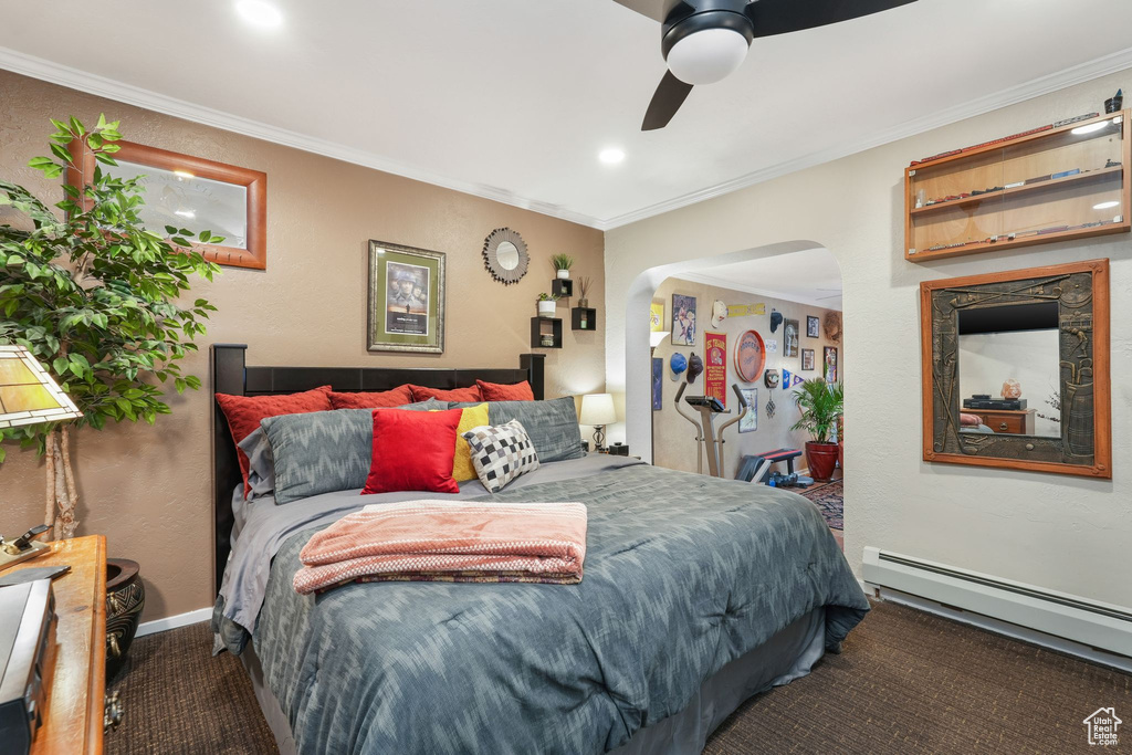 Carpeted bedroom featuring a baseboard radiator, arched walkways, ornamental molding, ceiling fan, and a textured wall
