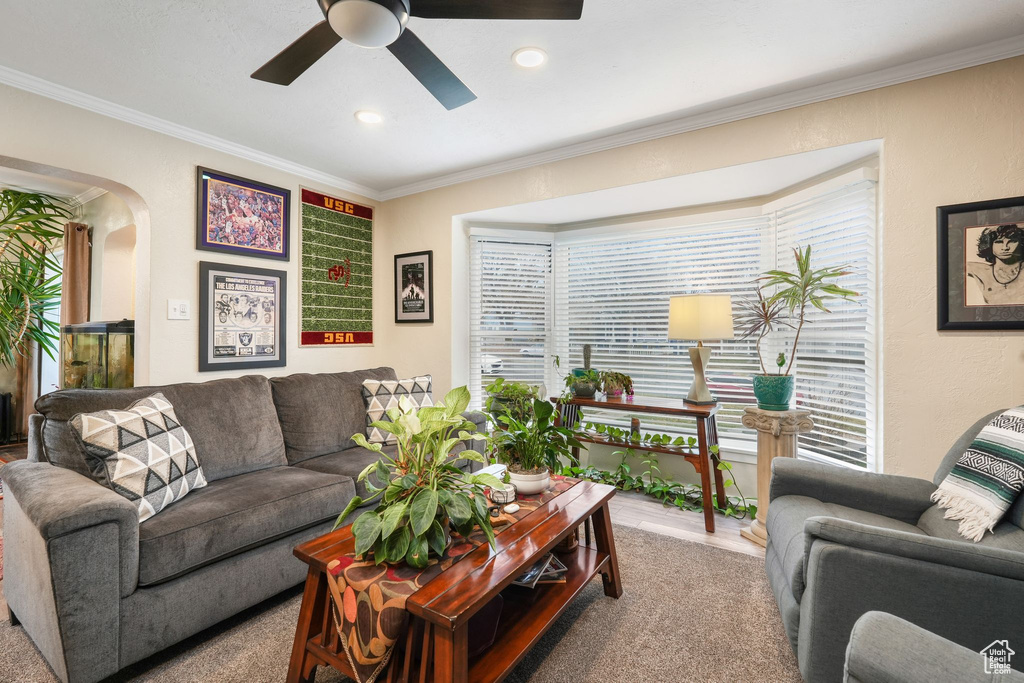 Living room with a ceiling fan, crown molding, arched walkways, and recessed lighting