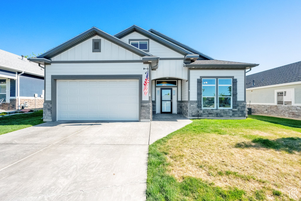Craftsman inspired home with stone siding, driveway, a garage, and board and batten siding