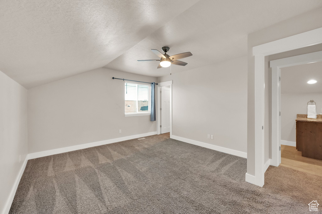 Bonus room with a ceiling fan, carpet floors, baseboards, and vaulted ceiling