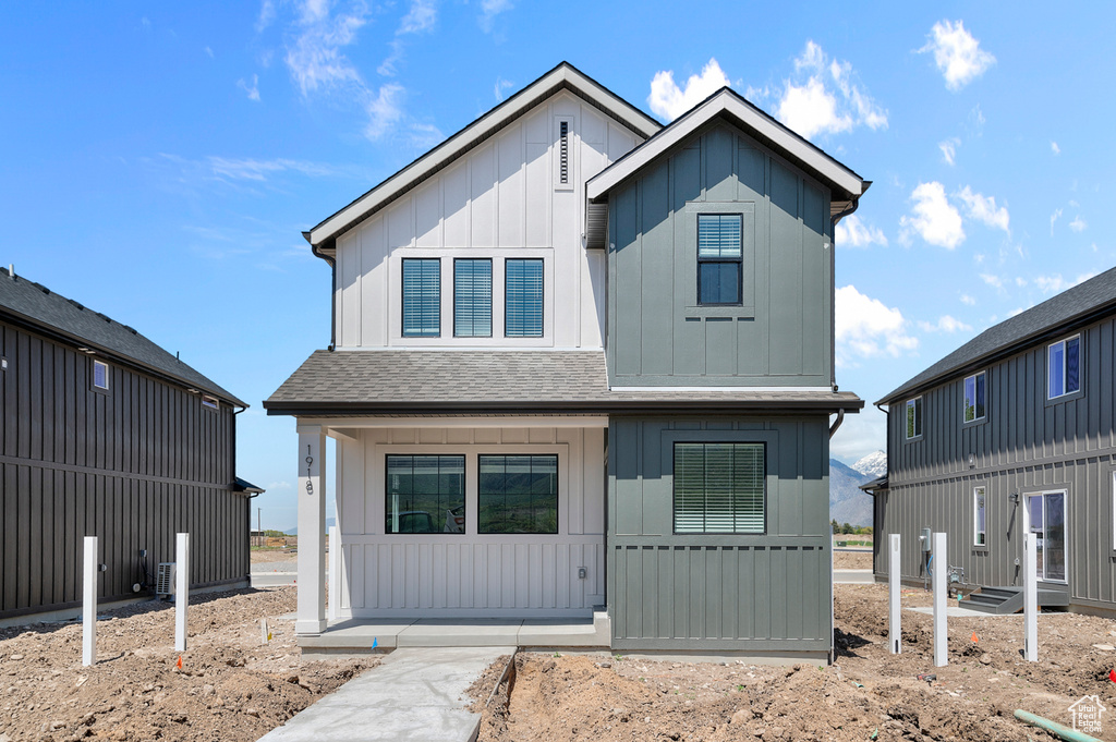 Modern farmhouse style home featuring board and batten siding and a shingled roof