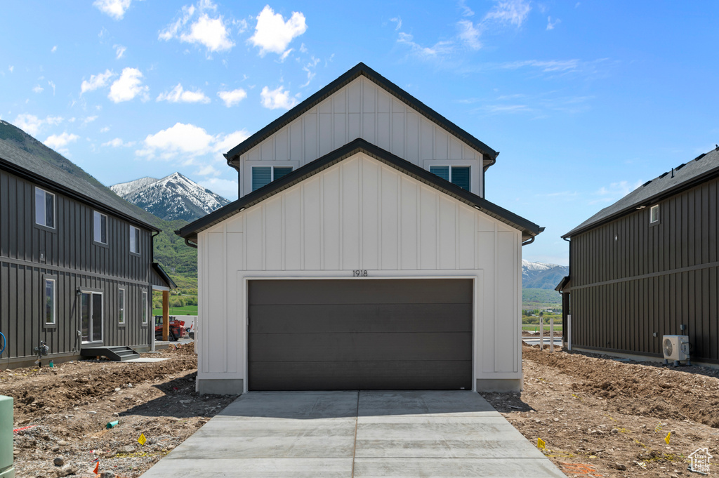 Garage featuring a mountain view, concrete driveway, and a cooling unit