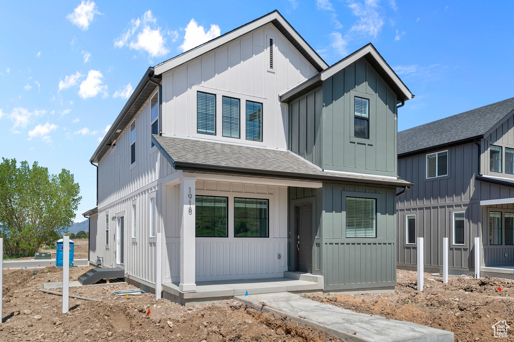 Modern farmhouse featuring a shingled roof and board and batten siding