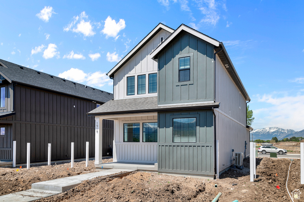 View of front of house with a shingled roof, board and batten siding, and a mountain view