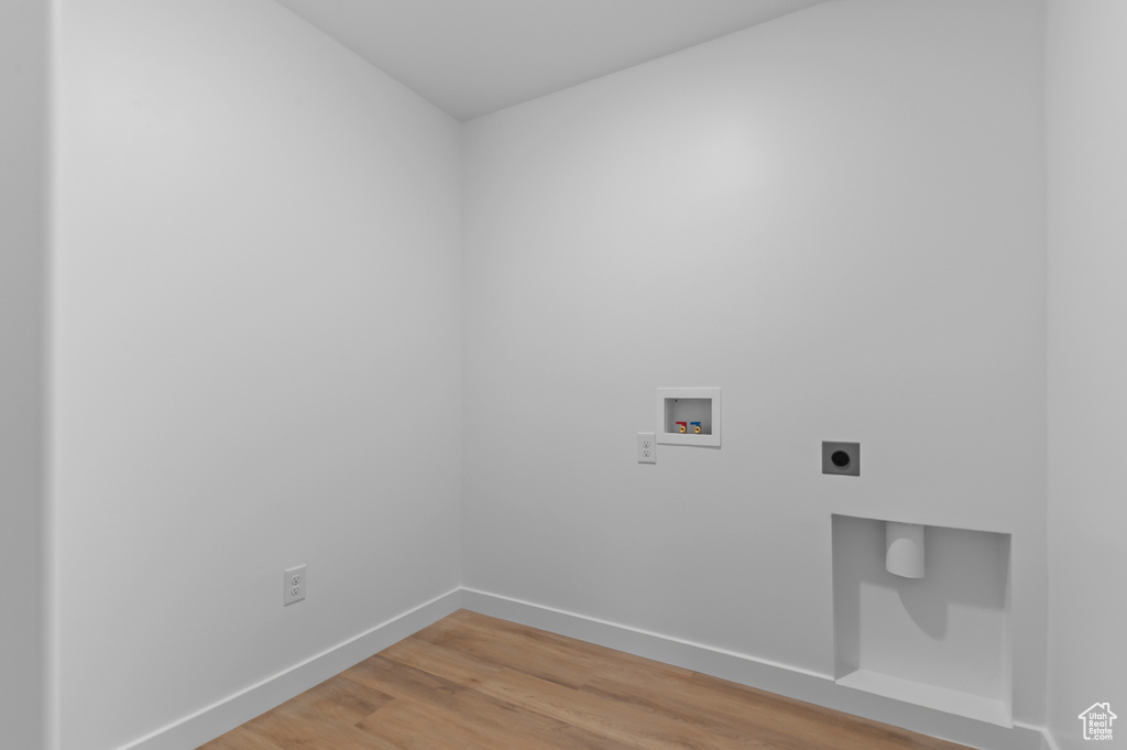 Laundry room with electric dryer hookup, washer hookup, light wood-type flooring, and baseboards