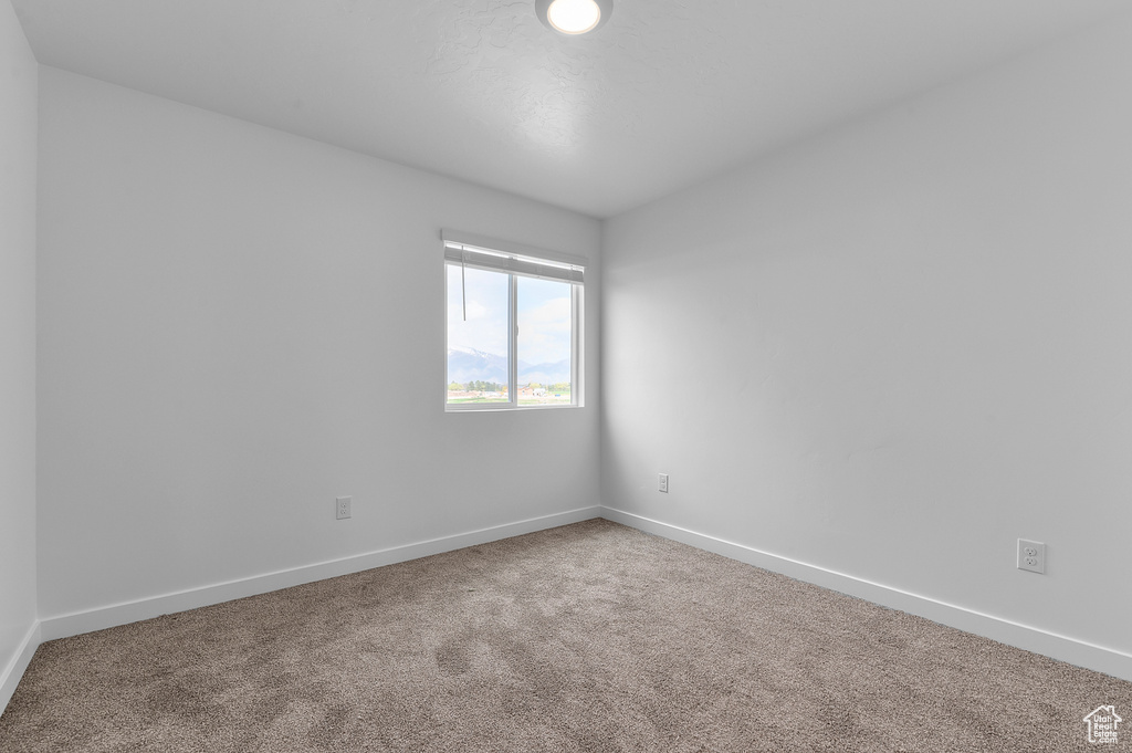 Empty room with carpet and baseboards