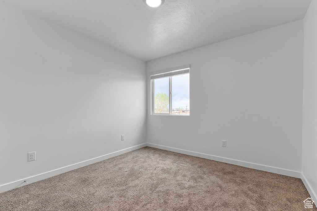 Unfurnished room with carpet flooring and baseboards