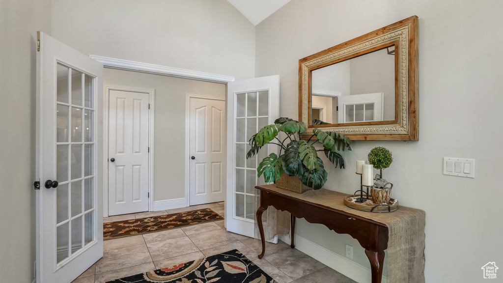 Entryway with french doors, high vaulted ceiling, and baseboards