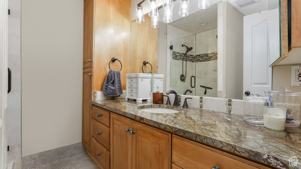 Full bathroom featuring a shower stall, tile patterned flooring, and vanity
