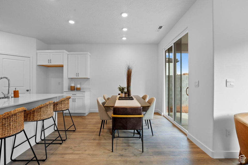 Dining room featuring plenty of natural light, light wood-style flooring, baseboards, and recessed lighting