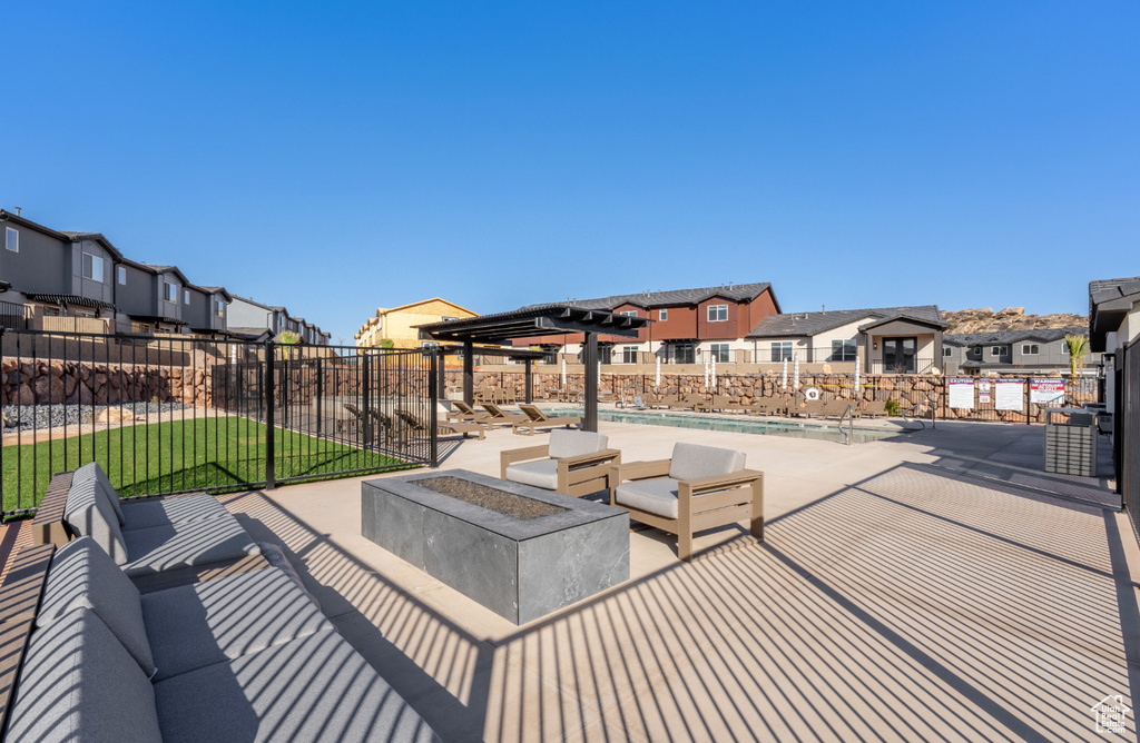 View of patio / terrace featuring a residential view, fence, and a community pool