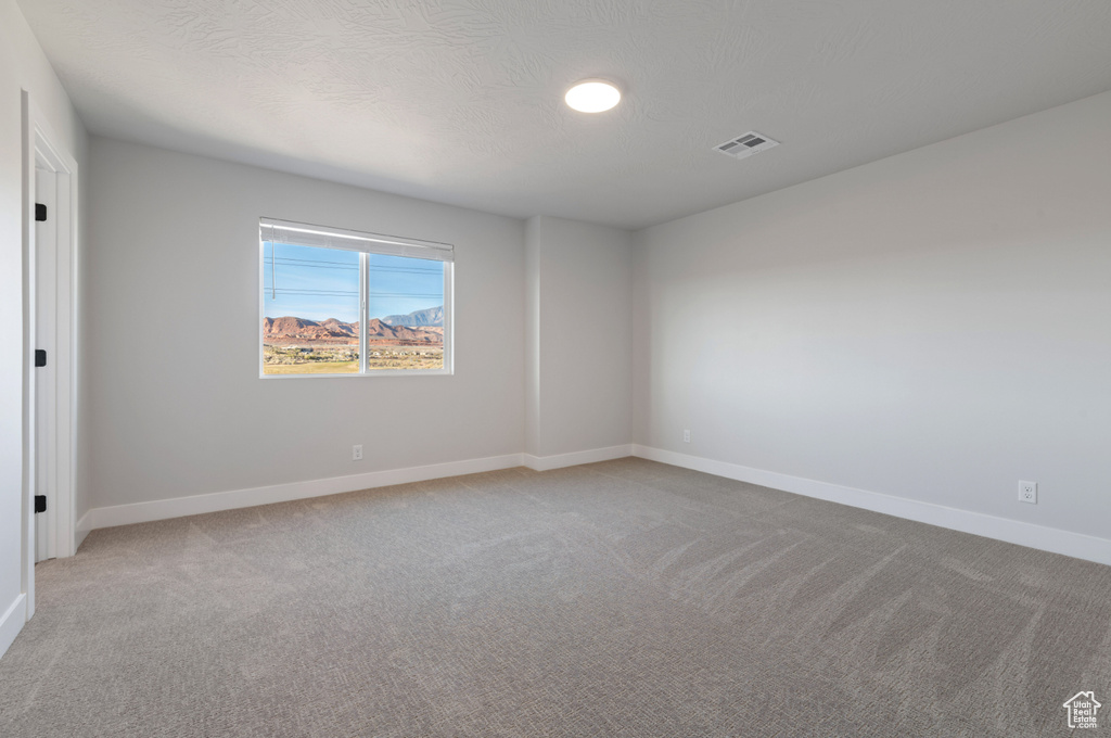 Unfurnished room with light colored carpet and baseboards