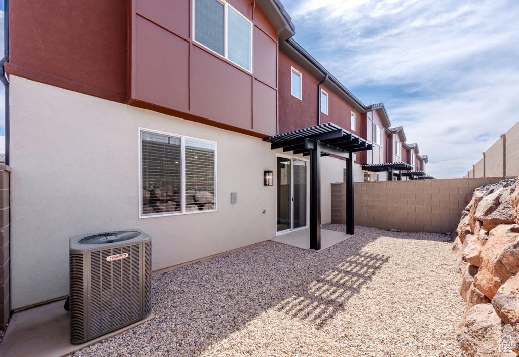 Back of house featuring central air condition unit, fence, stucco siding, and a patio area