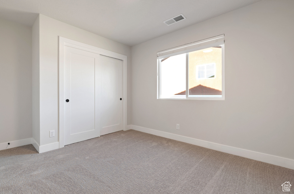 Unfurnished bedroom with carpet, baseboards, and a closet