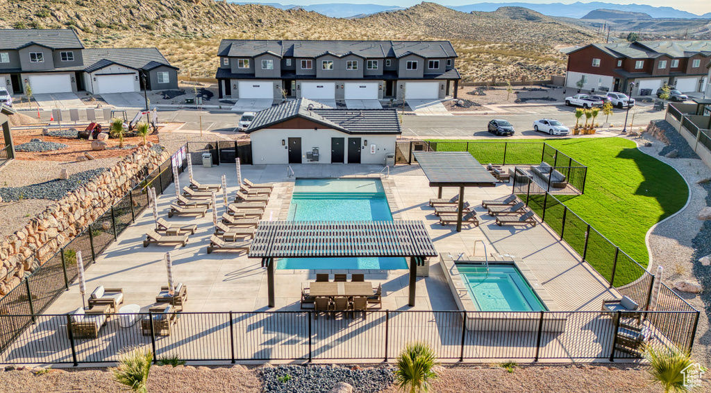 Community pool featuring a fenced backyard, a residential view, a mountain view, and a patio area